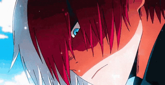 a close up of a person with red hair and blue eyes looking down .