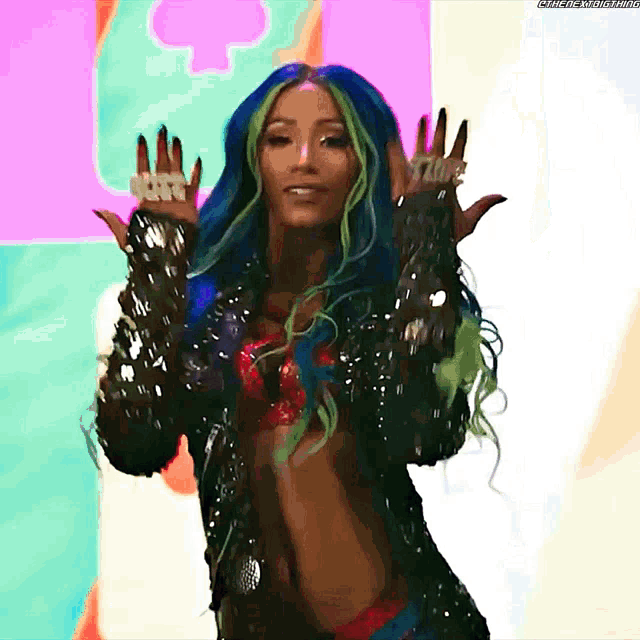 a woman with blue hair and green streaks is wearing a black jacket