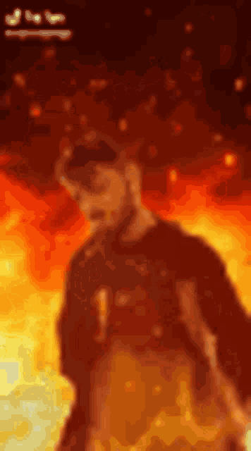 a man with a beard is standing in front of a fire background .