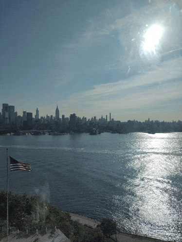 an american flag is flying in front of a city skyline