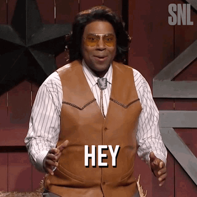 a man in a brown vest says hey