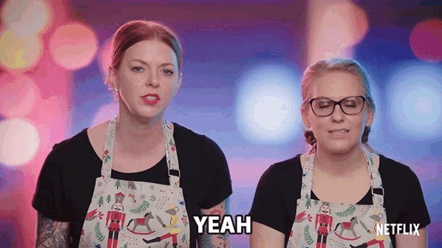 two women wearing aprons with nutcrackers on them say yeah