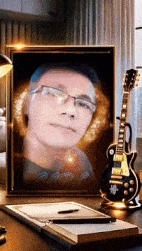 a portrait of a man with glasses and a guitar on a desk