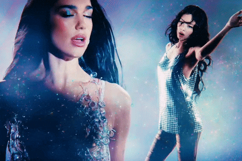 a woman in a plaid dress is dancing in a dark room