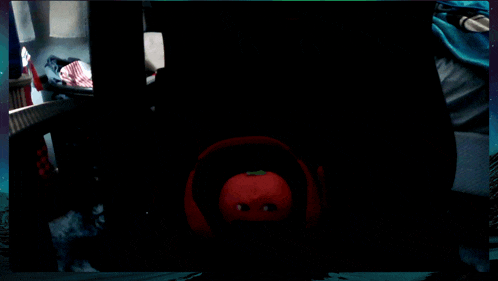 a red tomato with a green stem is in the dark