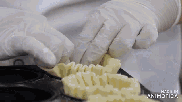 a close up of a person making a pastry with the words made in animotica behind them