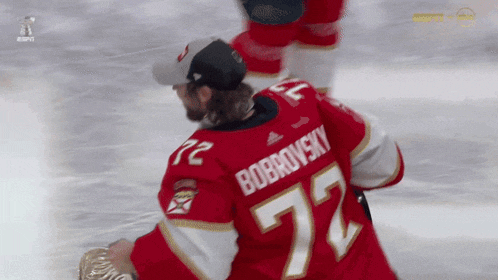 a hockey player wearing a red jersey with the number 72 on the back