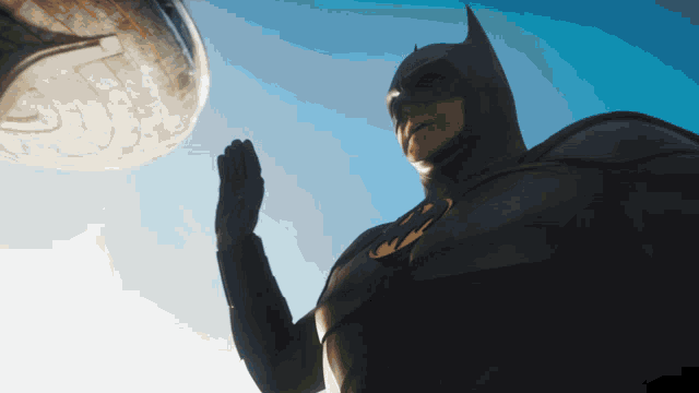 a man in a batman costume is standing in front of a large object