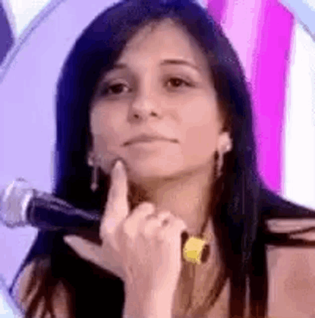 a woman is holding a microphone and making a face .