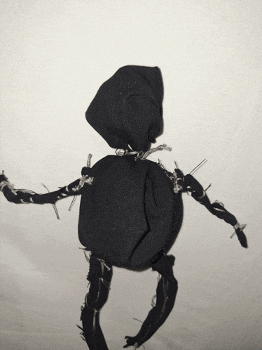 a black stuffed animal with barbed wire arms and legs