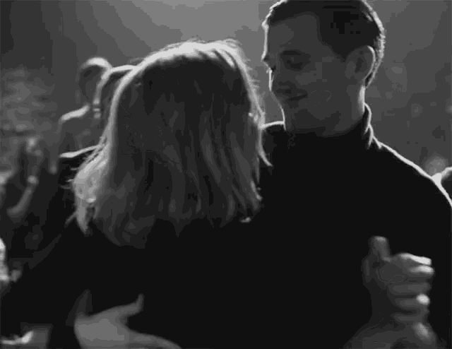 a man and a woman are dancing in a black and white photo
