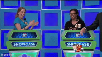 two women are standing in front of a green box that says showcase on it
