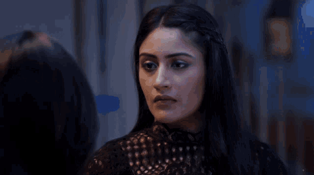 a woman in a black lace top is looking at herself in the mirror