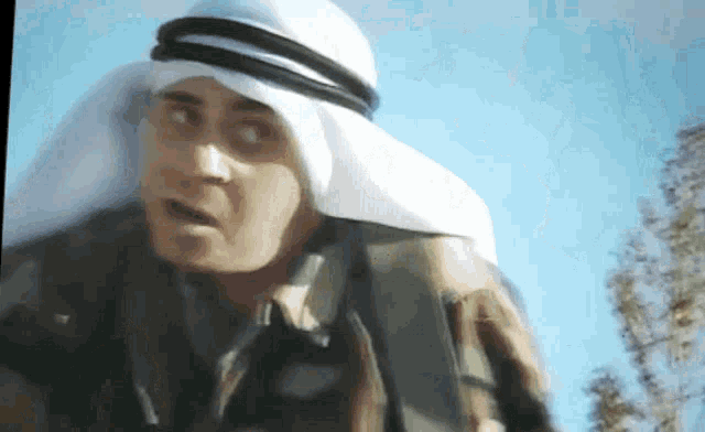 a man wearing a turban and a scarf around his head looks surprised