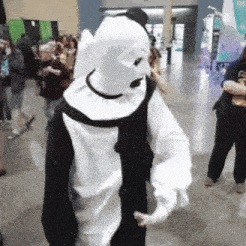 a person in a black and white clown costume is standing in a crowd