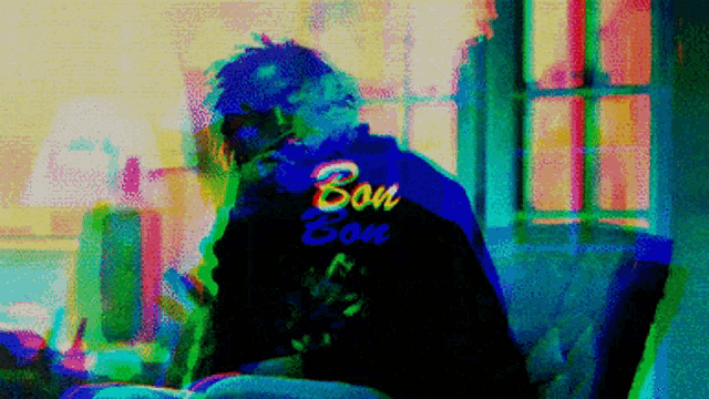 a blurry image of a person sitting on a couch with bon bon written on their back