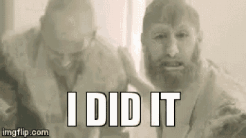 a man with a beard is standing next to another man with the words `` i did it '' written on it .
