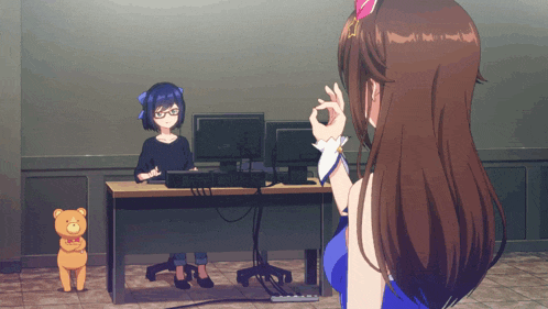a woman sits at a desk in front of a computer and a teddy bear
