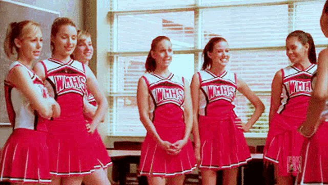 a group of cheerleaders wearing red uniforms that say wings
