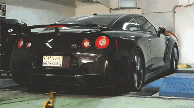 a black sports car with a license plate that says 6679 kk8