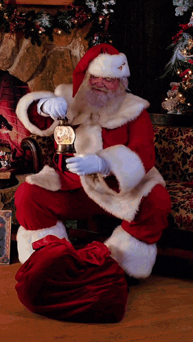 a man dressed as santa claus is holding a lantern in front of a fireplace