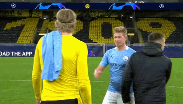 two soccer players on a field with a sign that says " load the app "