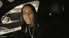 a man is sitting in the driver 's seat of a car .