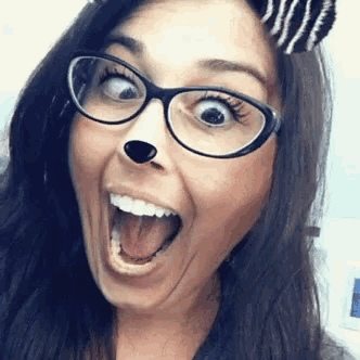 a woman wearing glasses and zebra ears is smiling with her mouth wide open