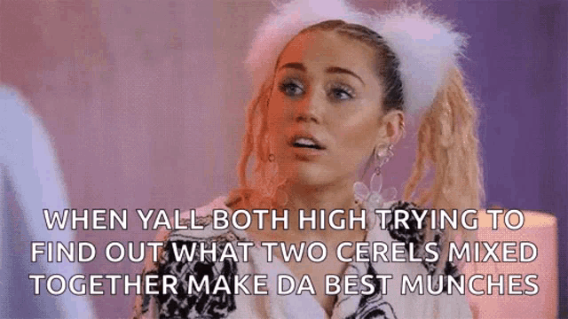 miley cyrus is wearing a furry headband and earrings while talking to a man .