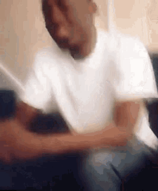 a blurry picture of a man sitting on a couch .