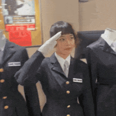 a woman in a suit salutes while wearing gloves and a name tag that says ' marie ' on it