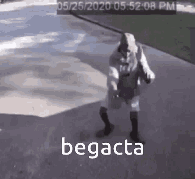 a person is walking down a sidewalk with a bag in their hand and the word begacta written on the ground .