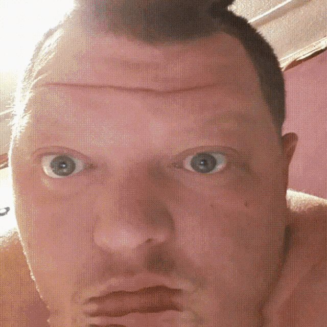 a close up of a man 's face with a beard and blue eyes