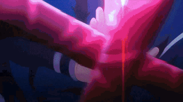 a person is holding a red object in their hand and a red light is coming out of it .