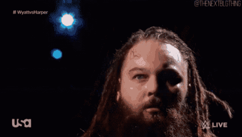 a man with dreadlocks and a beard is standing in front of a usa logo .
