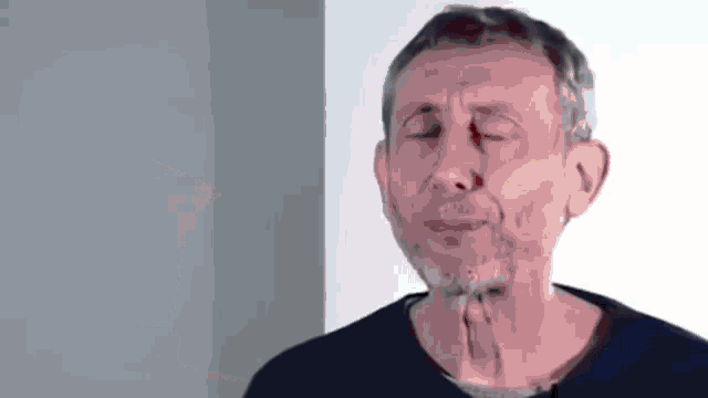 a man with a beard is crying with his eyes closed and his mouth open .