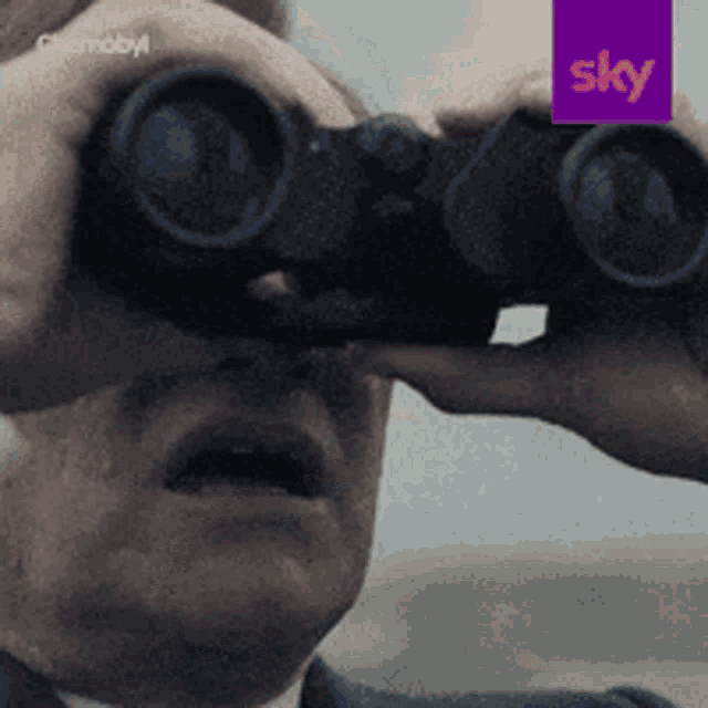 a man looking through binoculars with a purple sky logo in the background