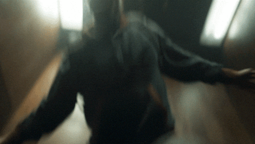 a blurred image of a person walking down a hallway