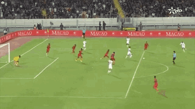 soccer players on a field with macao advertisements