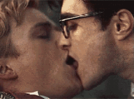 two men are kissing each other with their mouths open .