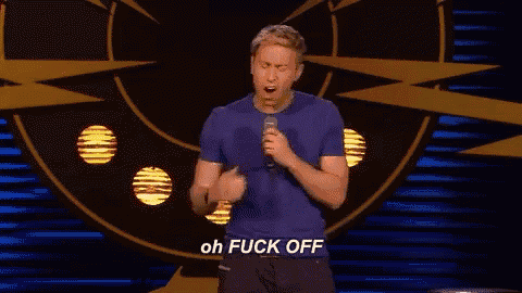 a man in a blue shirt is holding a microphone and saying oh fuck off .