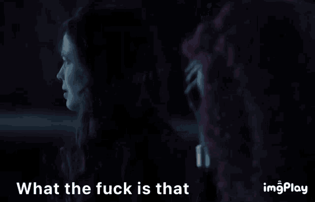 two women in a dark room with the words what the fuck is that behind them