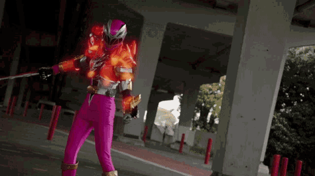a person in a pink and orange costume is holding a sword
