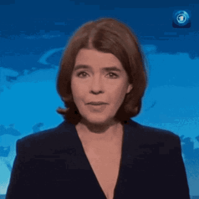 a woman in a blue suit is standing in front of a blue background