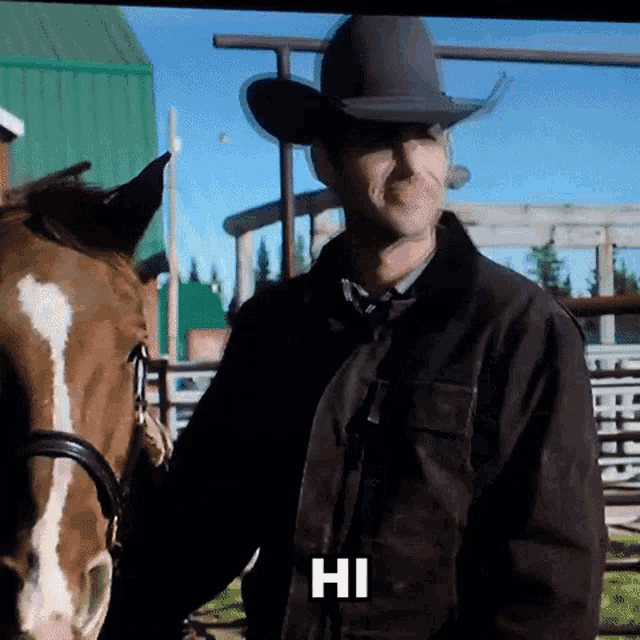 a man in a cowboy hat stands next to a horse and says hi on the screen