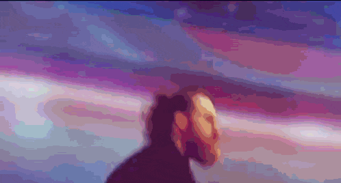 a blurry picture of a person standing in front of a cloudy sky
