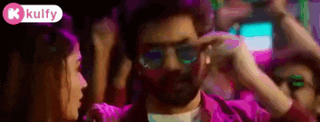 a man wearing sunglasses is dancing in a club with a woman .
