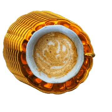 a cup of coffee on a saucer with a heart shaped foam