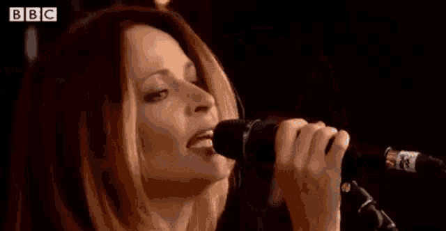 a woman is playing drums in front of a crowd at a music festival