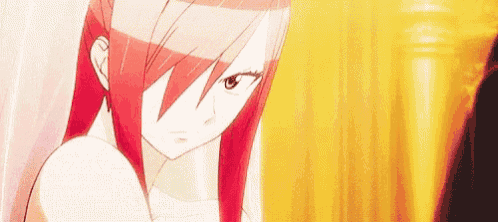 a close up of a girl with red hair standing in front of a yellow curtain .